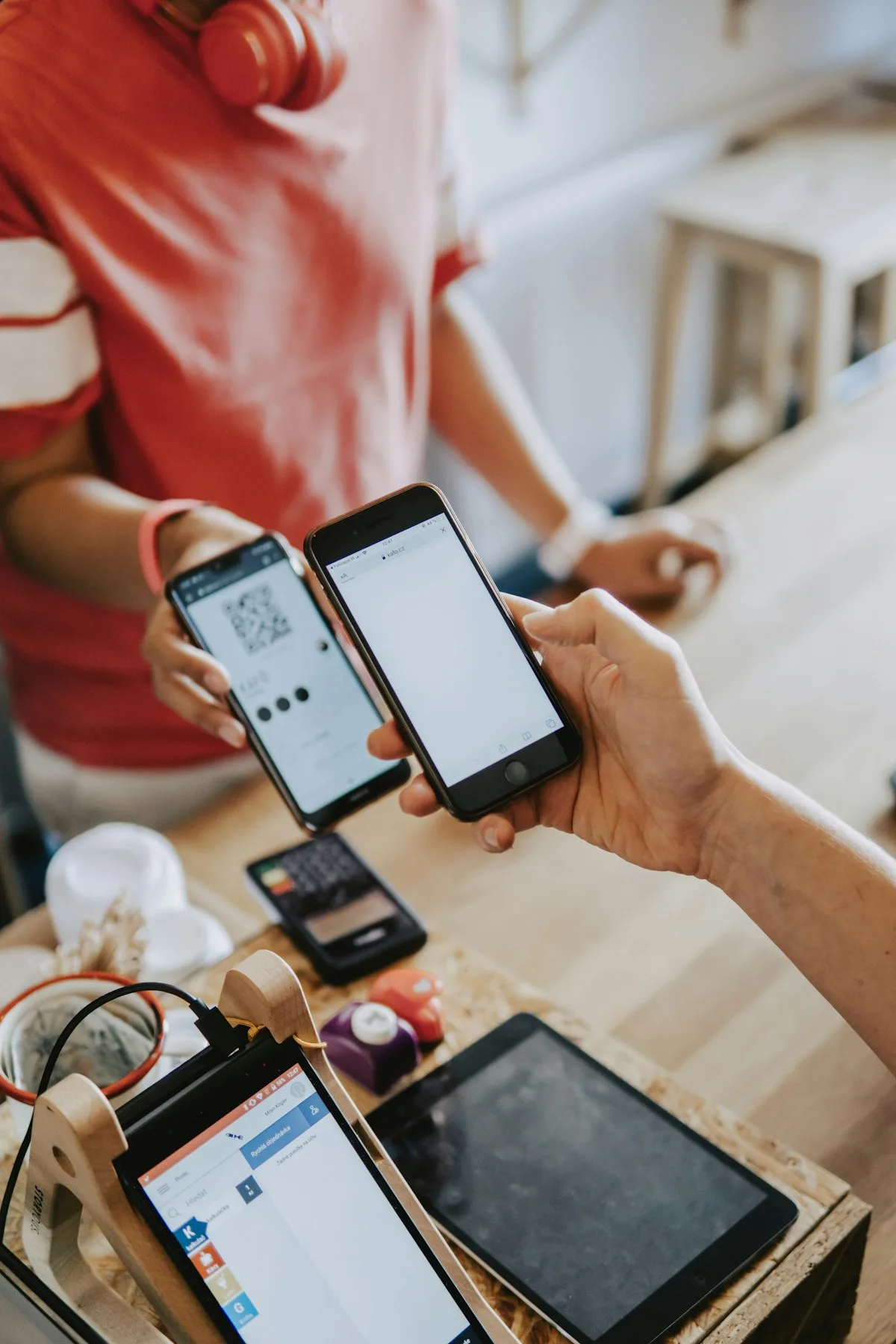 A customer scanning a QR code on a phone to pay at a shop counter