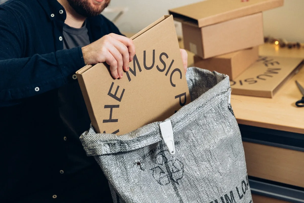 Someone packing a box into a shipping bag