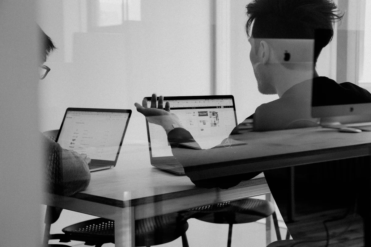 Two colleagues working through a task together at a laptop, a reminder that people and simple tools often win